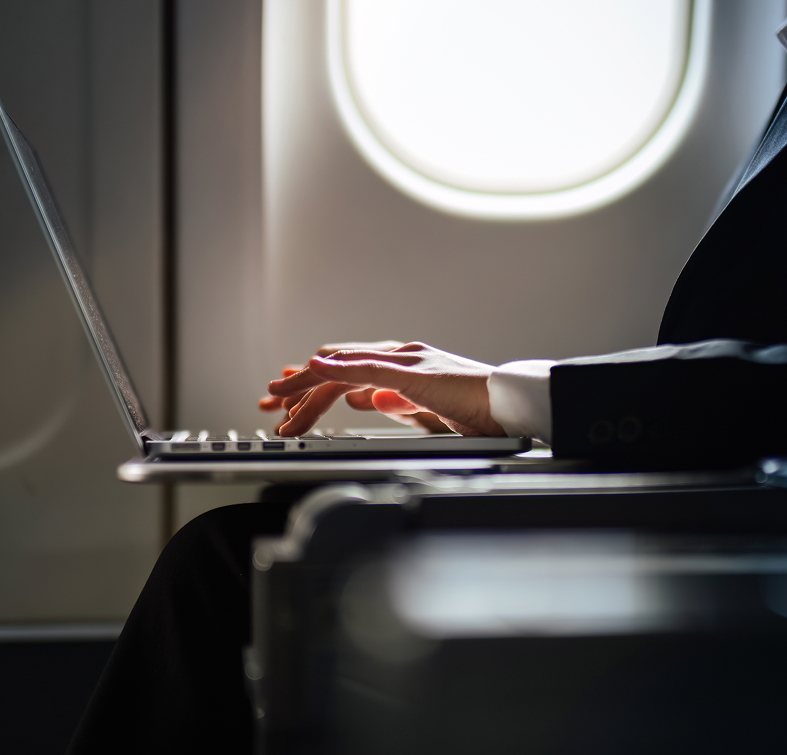 Business person typing on a plane