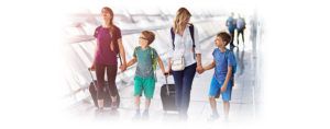 A woman walking with three kids and luggage at an airport