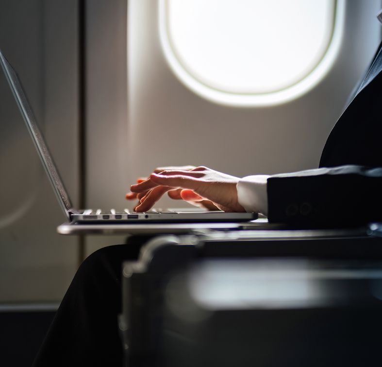 Business person typing on a plane