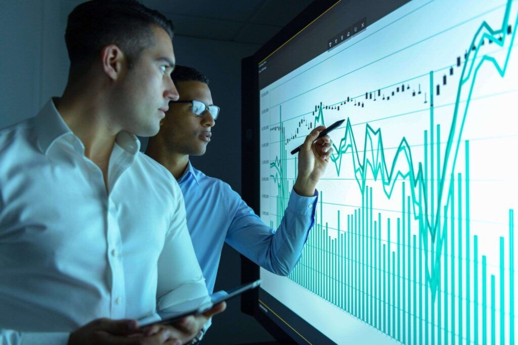Two men analyzing data on a screen